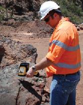 Delta Handheld XRF Analyzer testing a rock outside