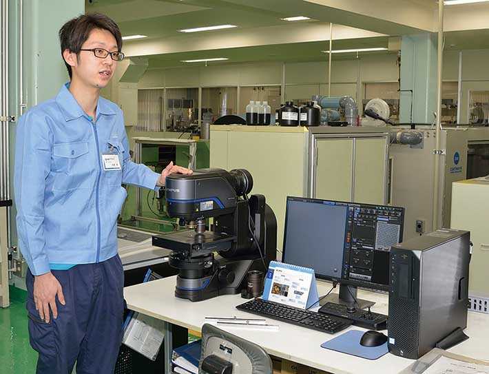 Laboratry technician in printng industry industrial lab setting using an Olympus DSX1000 digital microscope