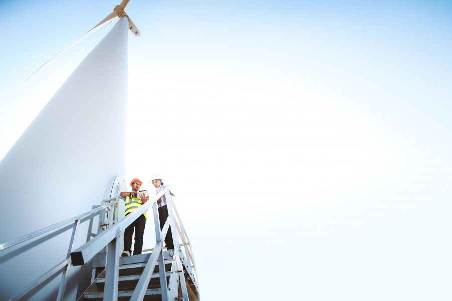 Inspectors at the base of a wind turbine
